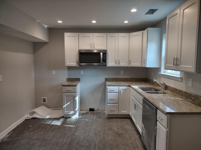 kitchen featuring dark wood-type flooring, a sink, stone countertops, appliances with stainless steel finishes, and white cabinets