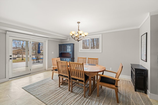 dining space featuring baseboards, a chandelier, and crown molding