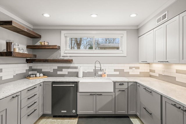 kitchen featuring visible vents, open shelves, gray cabinets, stainless steel dishwasher, and a sink