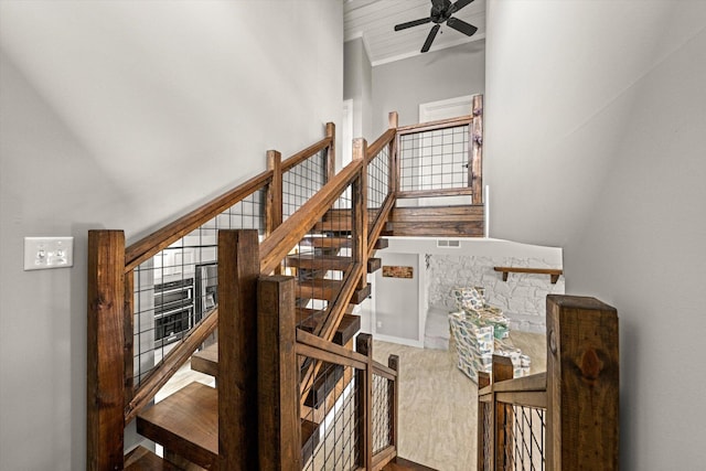 stairs featuring baseboards, a ceiling fan, and wood finished floors