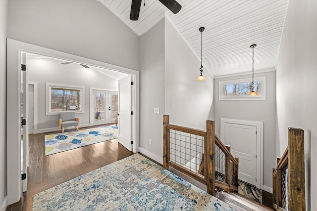 foyer with baseboards, hardwood / wood-style floors, a ceiling fan, and vaulted ceiling