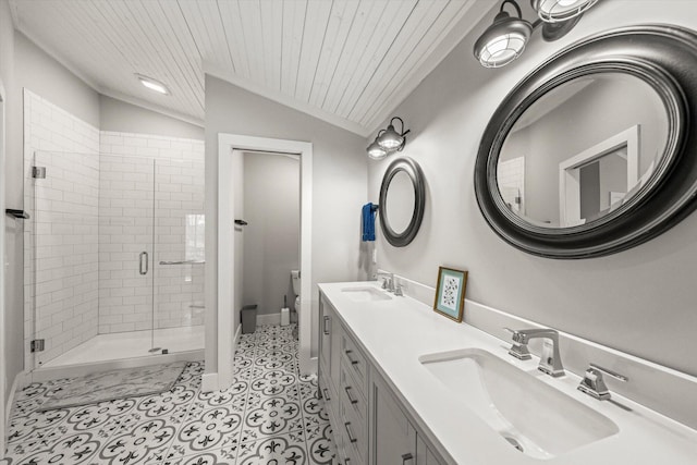 bathroom with a sink, toilet, a shower stall, and vaulted ceiling