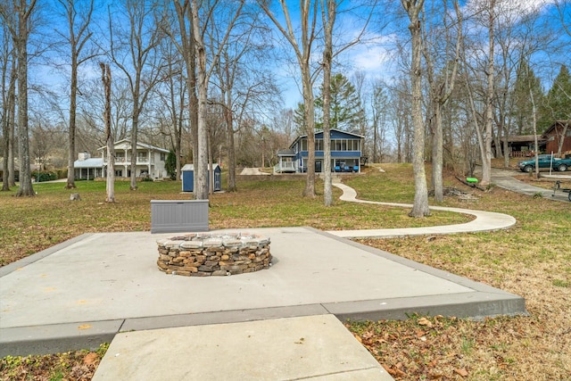 view of property's community featuring a lawn and a fire pit