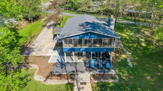 exterior space with a yard, a sunroom, a chimney, and stairway
