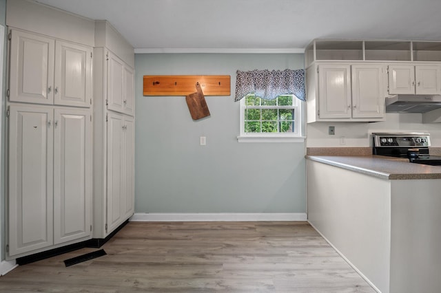 kitchen with under cabinet range hood, crown molding, white cabinets, baseboards, and stainless steel range with electric cooktop