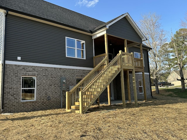 back of property with stairway and brick siding