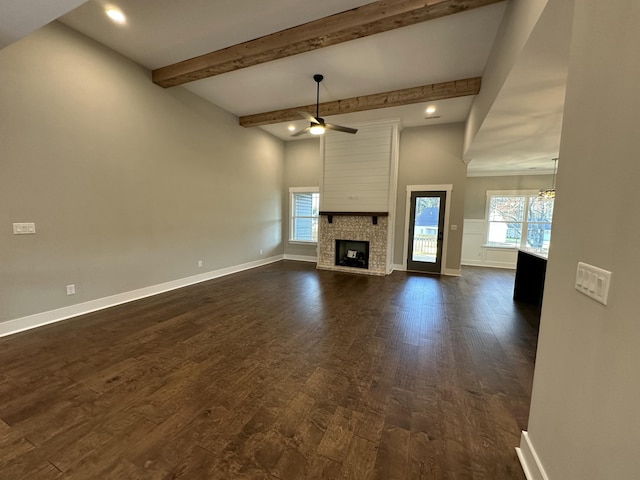 unfurnished living room featuring baseboards, beam ceiling, a fireplace, dark wood-style flooring, and ceiling fan