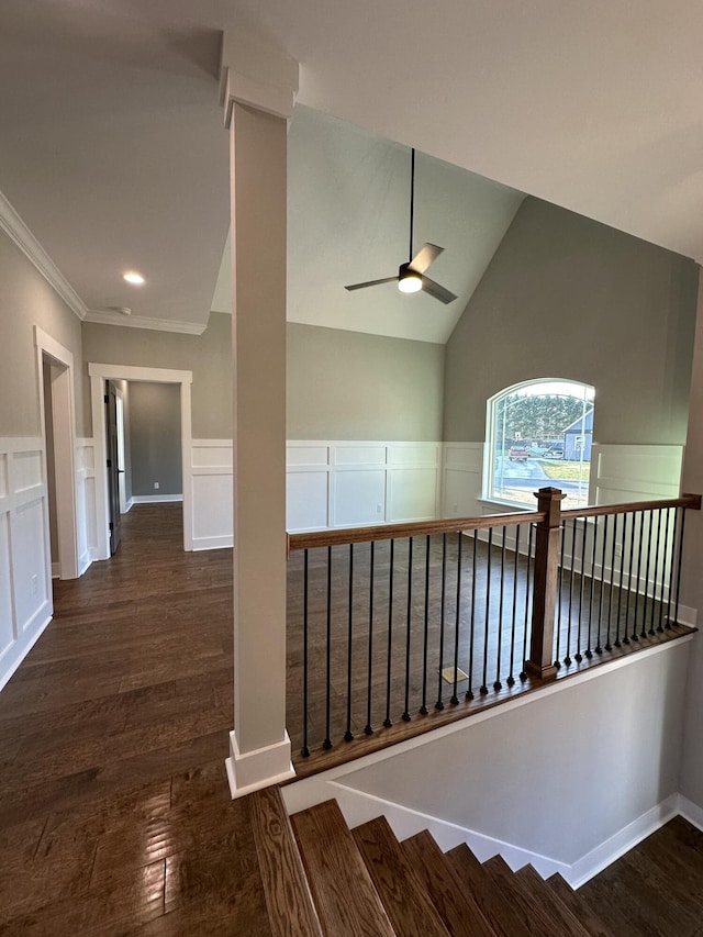 stairway with lofted ceiling, wood finished floors, a wainscoted wall, and ceiling fan