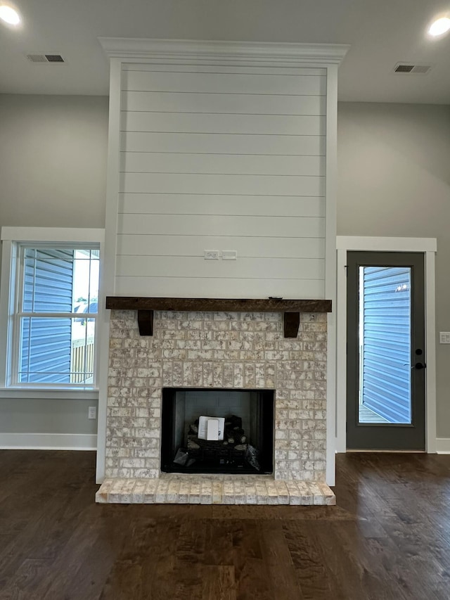 room details featuring visible vents, a fireplace, and wood finished floors