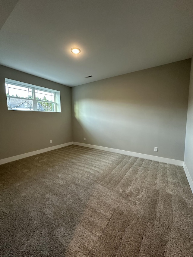 carpeted empty room with visible vents and baseboards