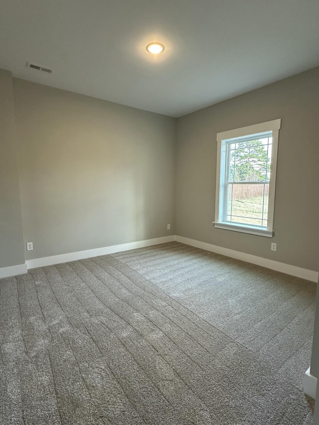 spare room with visible vents, baseboards, and carpet flooring