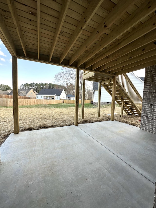 view of patio / terrace featuring a residential view, stairs, and fence