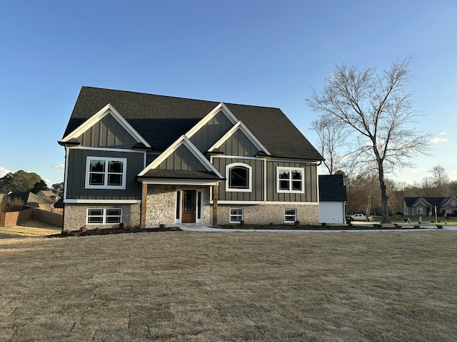 view of front of home with board and batten siding, a front lawn, and fence