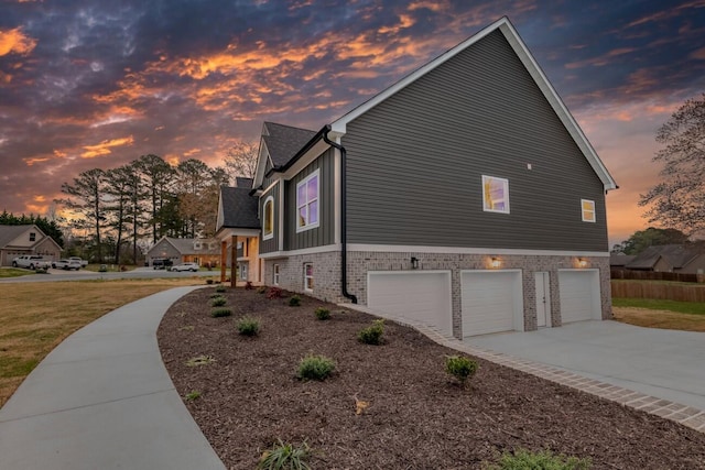 view of property exterior with concrete driveway and a garage