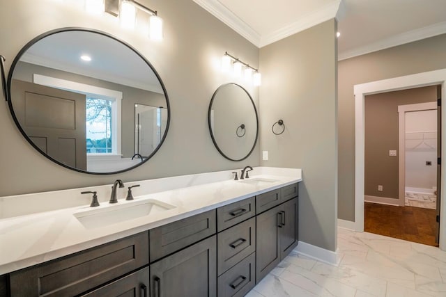 bathroom with marble finish floor, baseboards, ornamental molding, and a sink