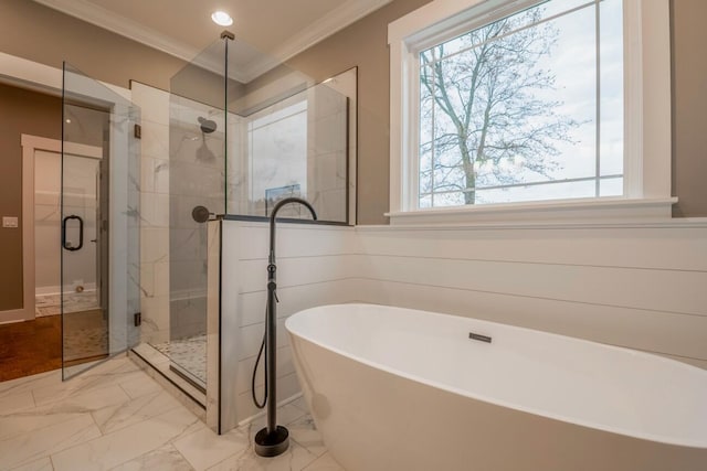 full bathroom with marble finish floor, ornamental molding, a freestanding tub, and a shower stall