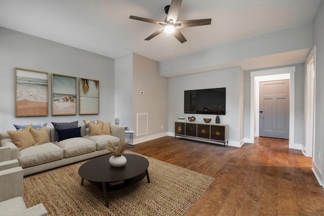 living room with a ceiling fan, wood finished floors, baseboards, and visible vents