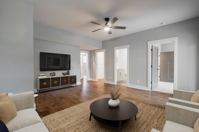 living room with baseboards, wood finished floors, and a ceiling fan