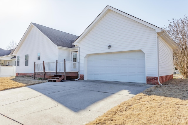 view of home's exterior with a wooden deck, concrete driveway, a garage, and roof with shingles