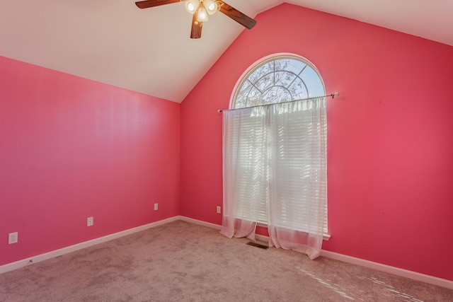 carpeted empty room with visible vents, lofted ceiling, baseboards, and a ceiling fan
