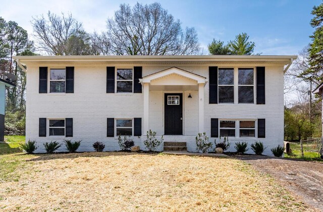 bi-level home featuring brick siding and a front yard