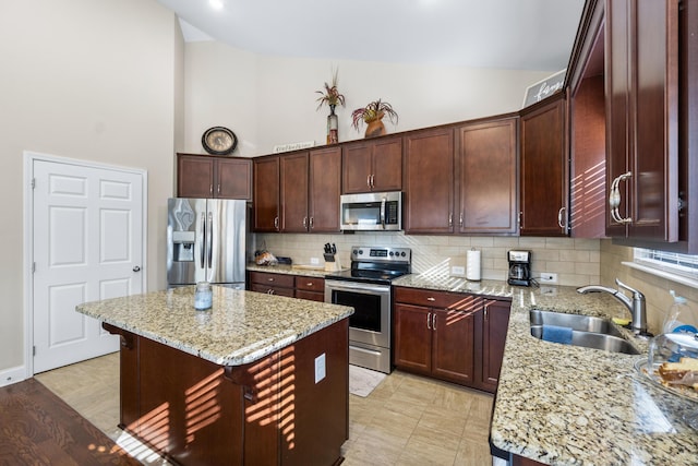 kitchen with light stone counters, high vaulted ceiling, a sink, appliances with stainless steel finishes, and backsplash