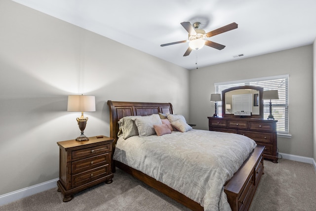 bedroom with baseboards, light carpet, visible vents, and ceiling fan