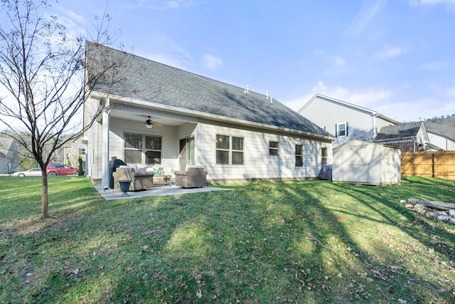 rear view of property featuring an outbuilding, a lawn, a ceiling fan, fence, and a storage shed