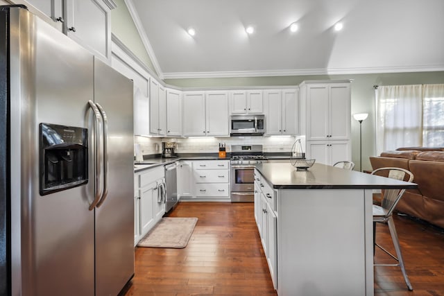 524 Ladd Ave, Chattanooga, TN 37405 - kitchen featuring a breakfast bar area, ornamental molding, decorative backsplash, appliances with stainless steel finishes, and dark countertops