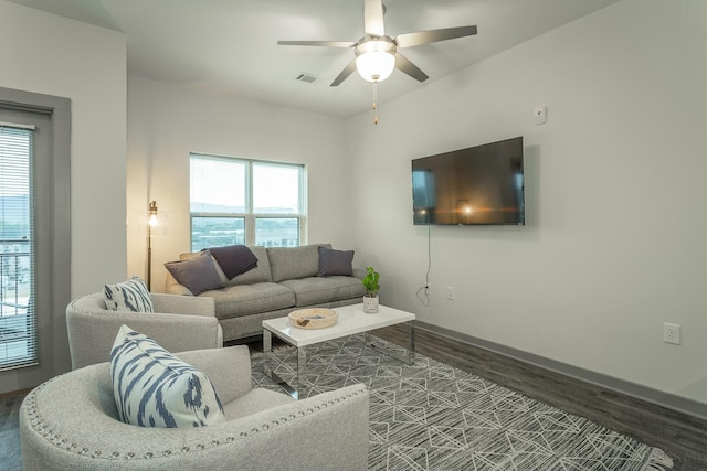 living room featuring visible vents, baseboards, wood finished floors, and a ceiling fan