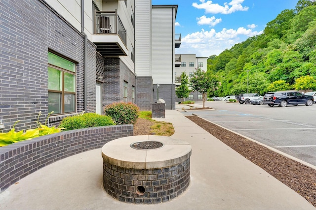 view of property's community featuring a fire pit and uncovered parking