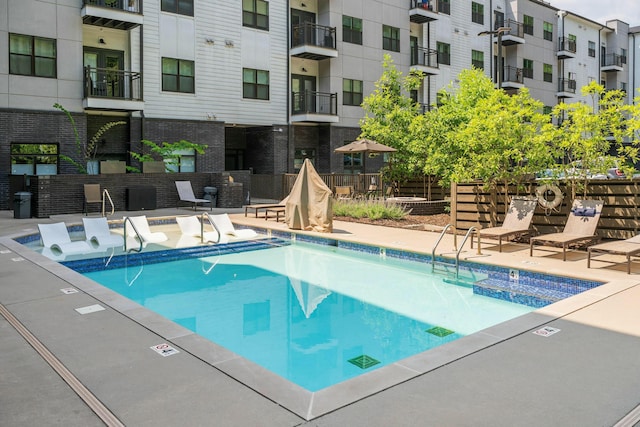 pool with a patio and fence