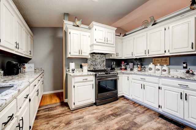 186 Joann Dr SE, Calhoun, GA 30701 - kitchen featuring white cabinetry, light stone countertops, light wood-type flooring, and stainless steel gas range