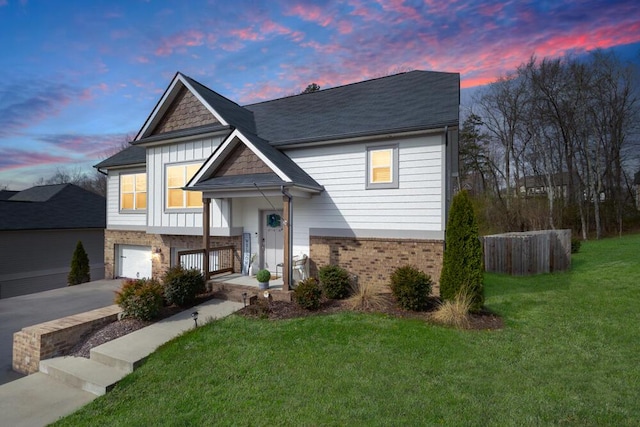view of front facade with a yard, concrete driveway, an attached garage, board and batten siding, and brick siding