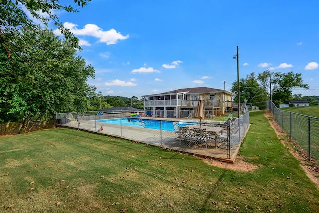 community pool with a fenced backyard, a lawn, a sunroom, and a patio area