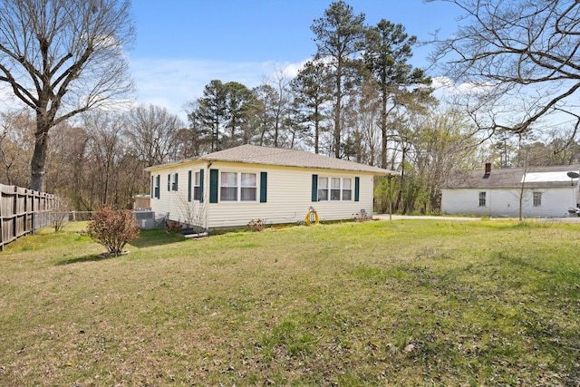 rear view of property with a lawn and fence