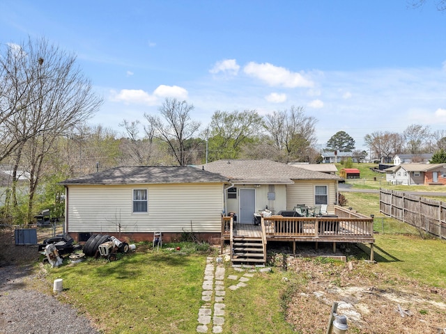 back of property featuring a lawn, fence, and a wooden deck