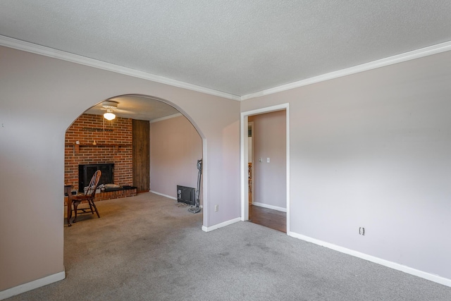 2011 Robbins St, Chattanooga, TN 37404 - unfurnished living room featuring crown molding, a brick fireplace, carpet flooring, a textured ceiling, and arched walkways