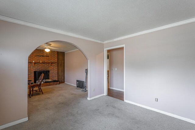 2011 Robbins St, Chattanooga, TN 37404 - unfurnished living room featuring crown molding, a brick fireplace, carpet flooring, a textured ceiling, and arched walkways