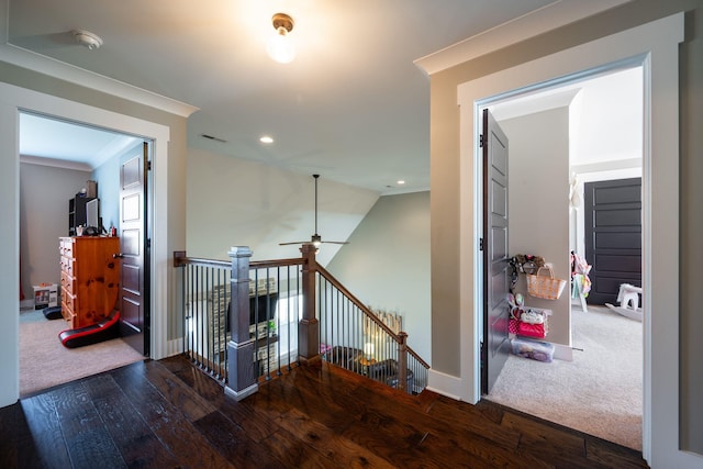 hallway featuring visible vents, an upstairs landing, ornamental molding, hardwood / wood-style flooring, and baseboards