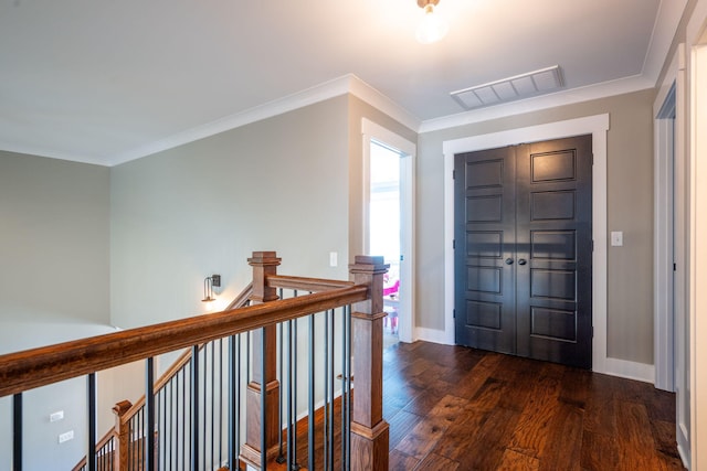 entryway with visible vents, crown molding, dark wood-type flooring, and baseboards