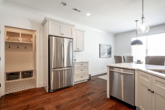 kitchen featuring dark wood finished floors, visible vents, stainless steel appliances, and light stone counters