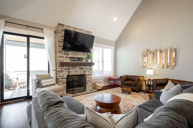 living room featuring a fireplace, wood finished floors, baseboards, and high vaulted ceiling