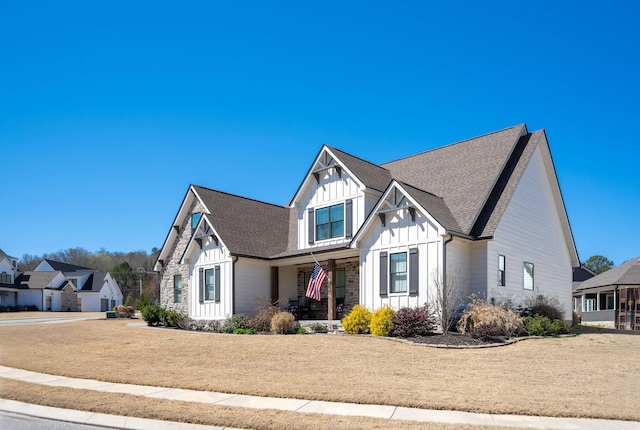 modern farmhouse featuring a residential view, covered porch, board and batten siding, and a shingled roof