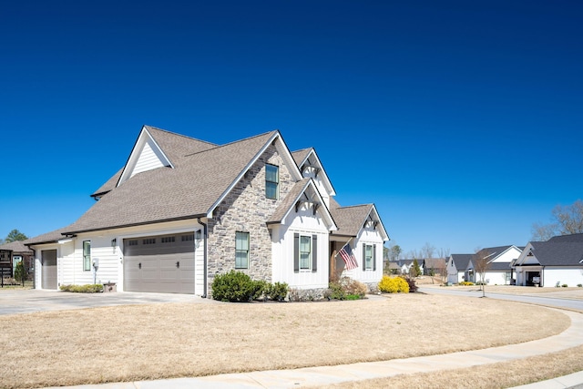 view of front of property with a shingled roof, a residential view, driveway, stone siding, and an attached garage
