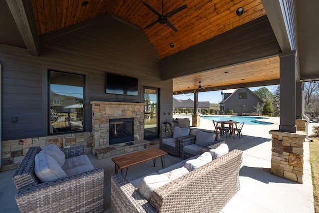 view of patio featuring an outdoor pool, a ceiling fan, and an outdoor living space with a fireplace