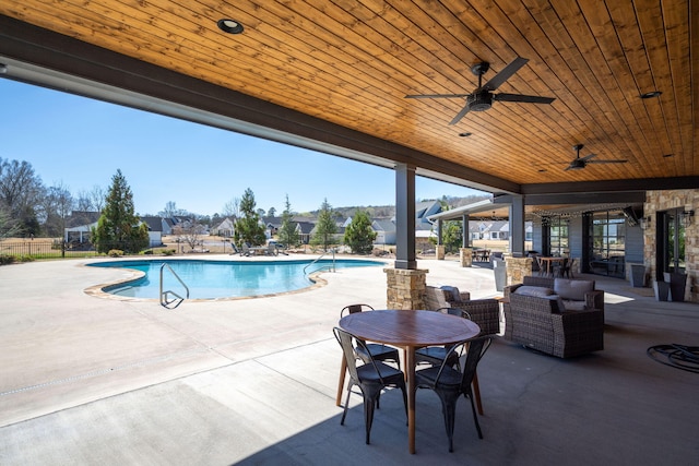 pool with a patio area, outdoor dining space, ceiling fan, and fence