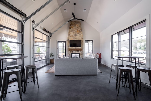 living area with a ceiling fan, visible vents, baseboards, high vaulted ceiling, and a fireplace