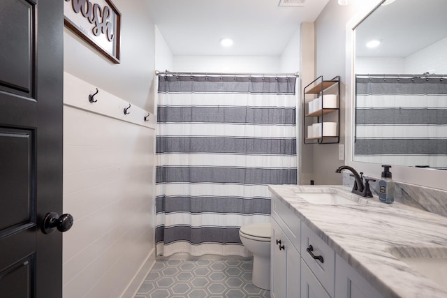 bathroom featuring visible vents, curtained shower, toilet, double vanity, and a sink