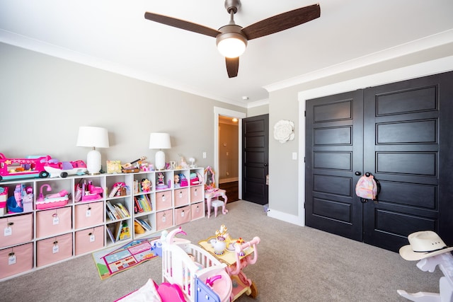 rec room featuring ceiling fan, baseboards, carpet floors, and ornamental molding